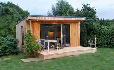 Studio en bois clé en main livré monté dans un jardin paysager